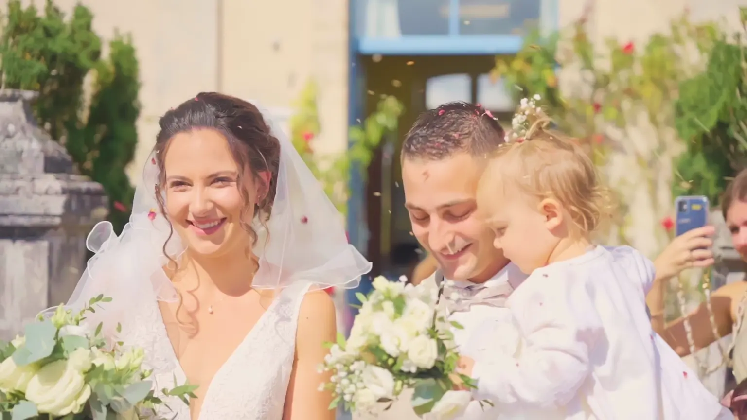 Les mariés avec un enfant à la sortie de la cérémonie